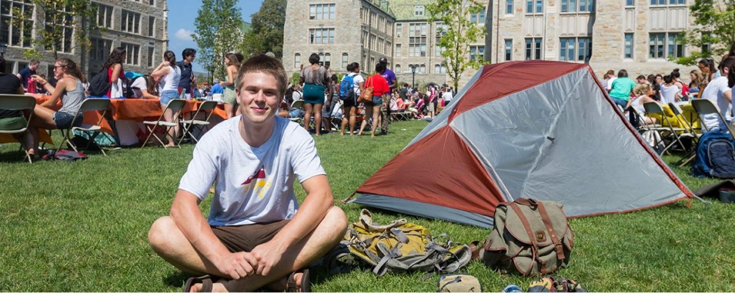 Boy sitting on grass during student fair