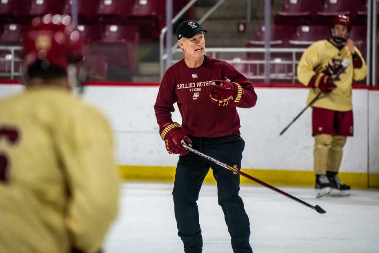 Coach Greg Brown coaching on ice with players.