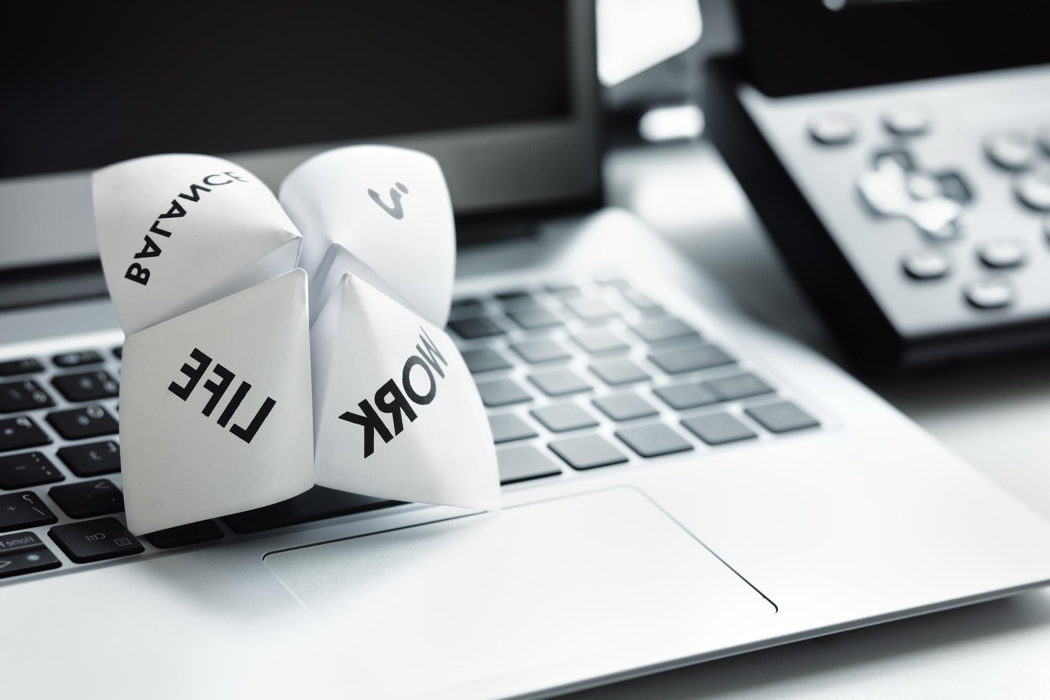 A paper fortune teller rests on a laptop 